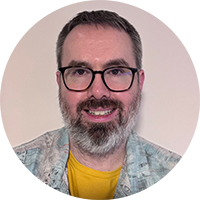 person wearing glasses smiling at the camera