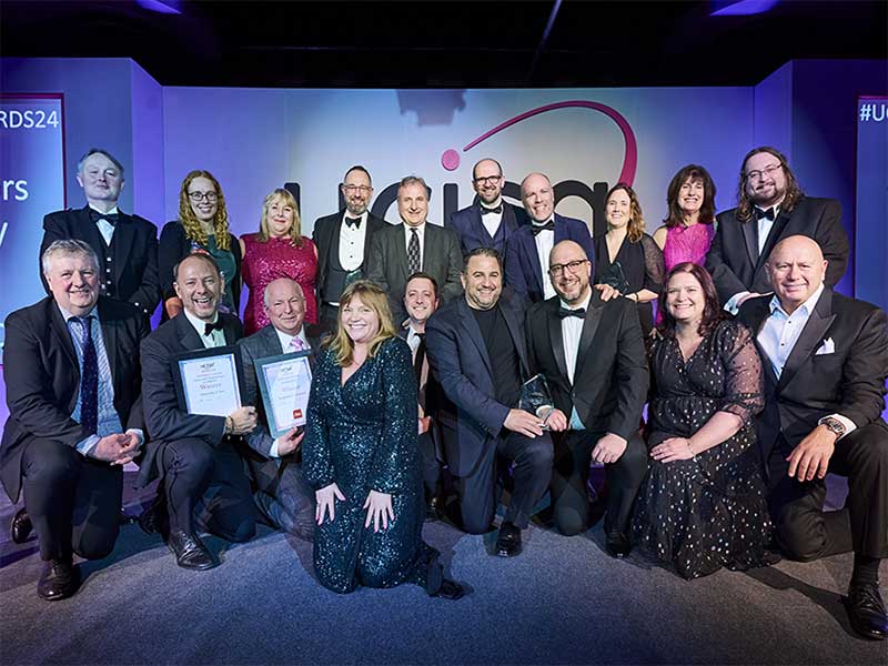 group shot of UCISA24 awards winners on stage with after dinner speaker Kate Bottley