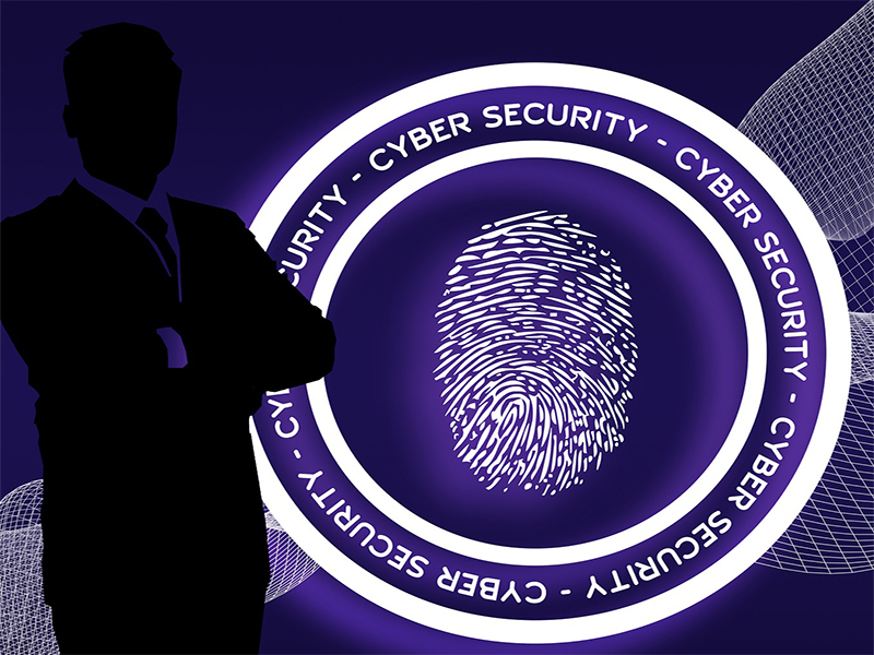 shadow of a man stood in front of large round with cyber security around a thumb print