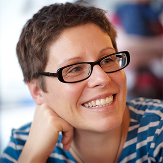 woman with short hair and glasses smiling 