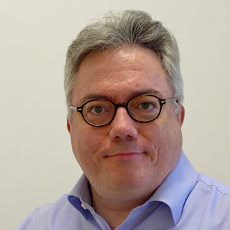 man with short hair and glasses smiling