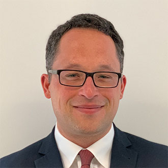 person wearing glasses smiling at the camera