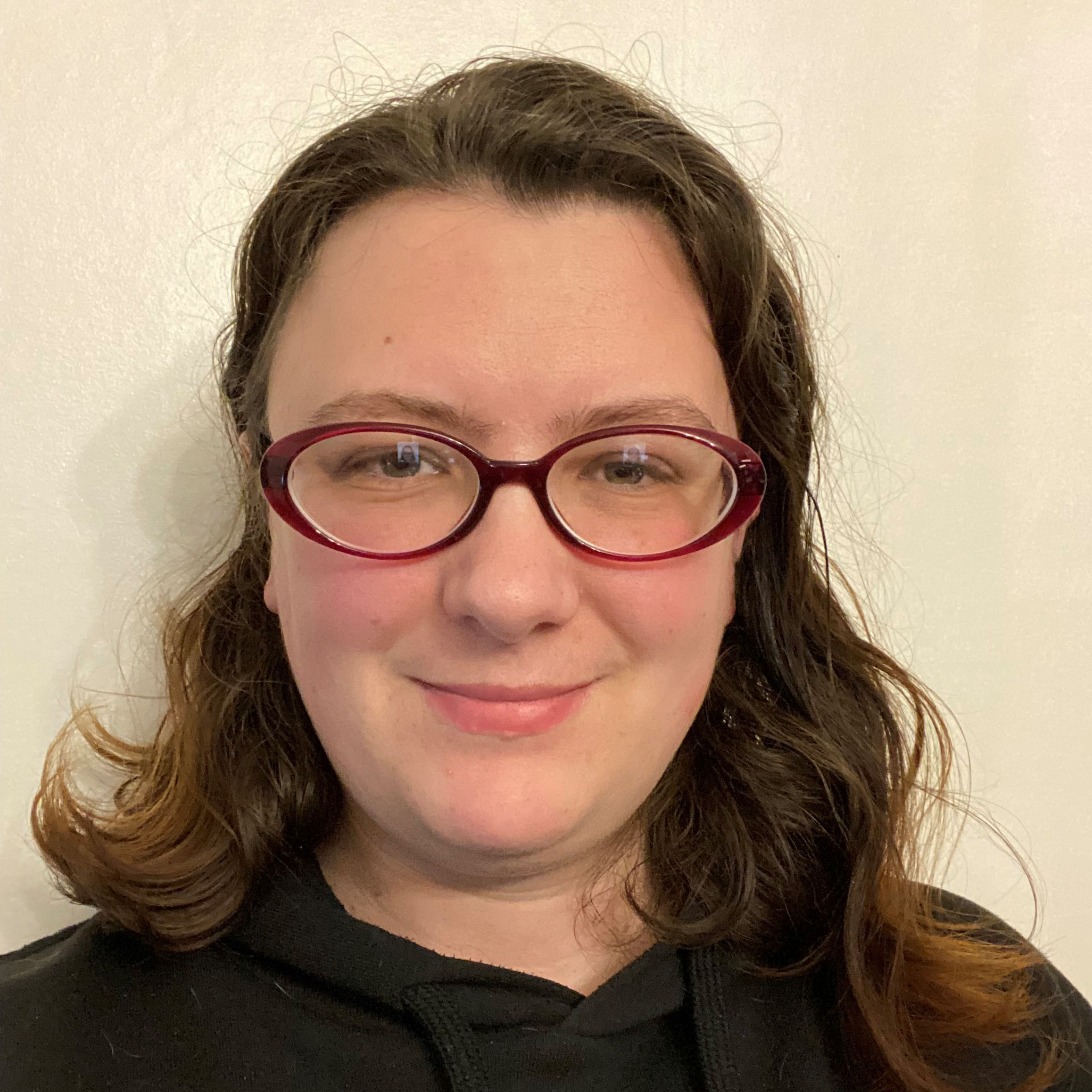 woman with long hair and glasses smiling