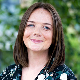 person with shoulder length hair smiling at the camera