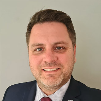 head shot of a man in a suit and tie smiling at the camera