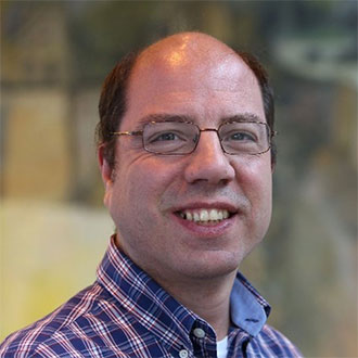 person with glasses smiling at camera