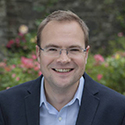 head and shoulders shot of man with glasses