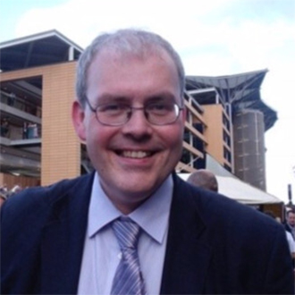 man wearing glasses and in suit an tie smiling