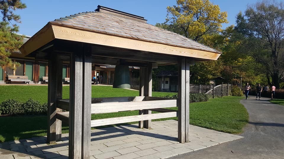 Photograph of the Peace Bell in the Japanese Garden in Montreal's Botanical Garden under its wooden structure