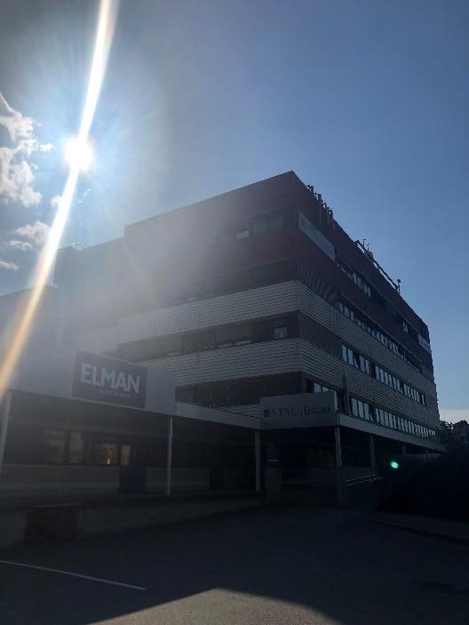 Colour photograph of the exterior of a multi-story building in the sunshine